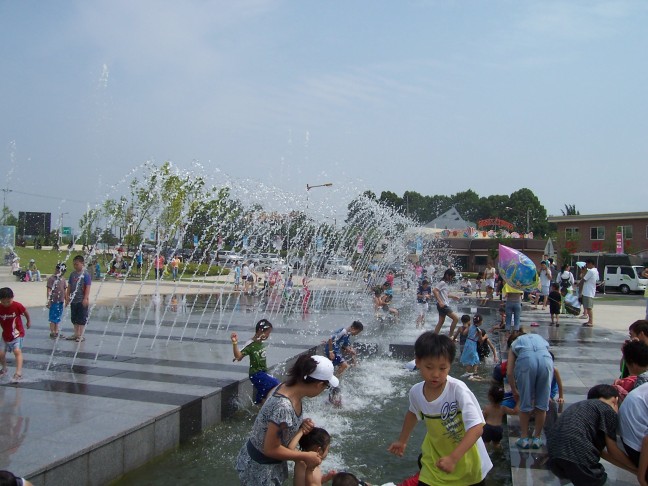 A random spouting fountain invites children to play at the DMZ parking lot.