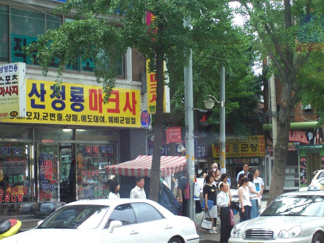 Busy shops. Sign reads something like Shan-chaung-ryong Mah-keh-sah