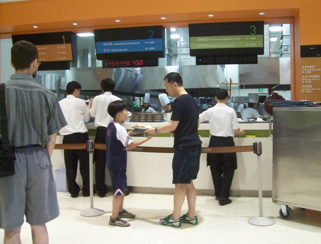 The cooks behind the counter pass food to the staff in front. They hand it to you. Sometimes you hand it to your kid.