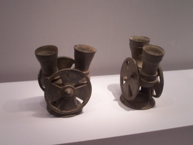 Metal pots with wheel decorations.