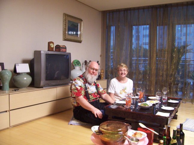 Fred and Susan sitting down to dinner in Prof. Lee's apartment.