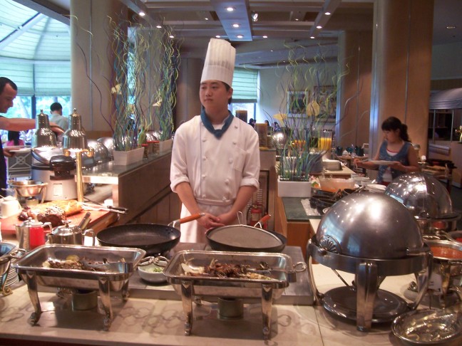 The Hilton buffet chef is eager to please whe you want a serving, but disinterested in being part of a picture.