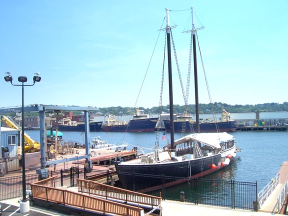 Modern tankers line the shore opposite the wooden antiques