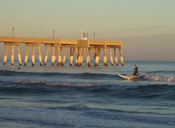 Catching a wave at sunset near Johnnie Mercer's pier