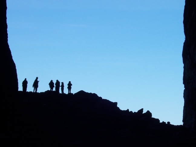 Hikers about to descend the exit from the hole piercing Torghatten