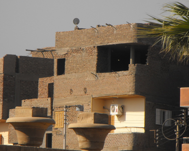  Though the top floor is uninhabitable, someone below uses electricity, an air conditioner, and a satellite dish; a common situation in Egypt