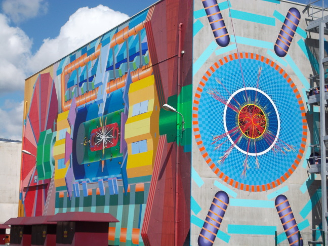  At CERN, the outside of the 4-story ATLAS control center is decorated with a schematic of the detector. Blue capsules detect muons.