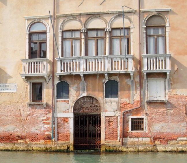  Tidal waters have benn unkind to this door as to so many others in Venice. Finding one's way is aided by numerous signs such as the one at the left for "Parrochia Di S. Stefano."