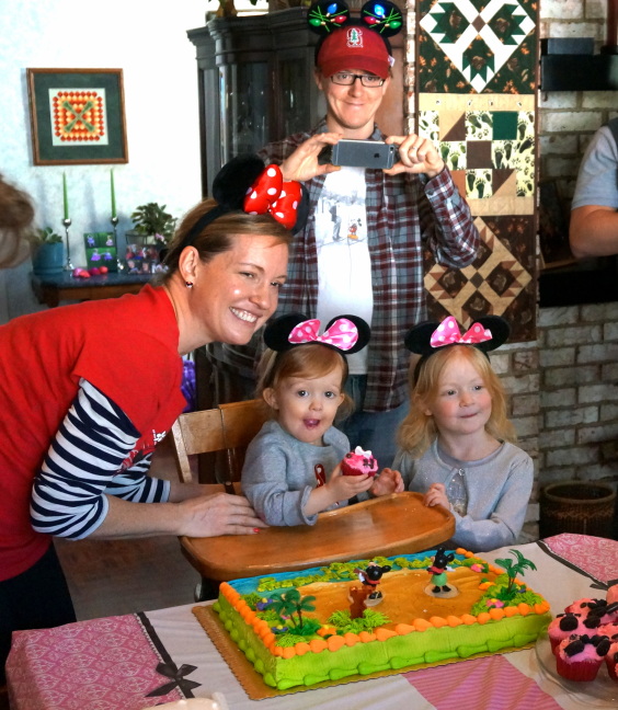 The whole family poses around the cake