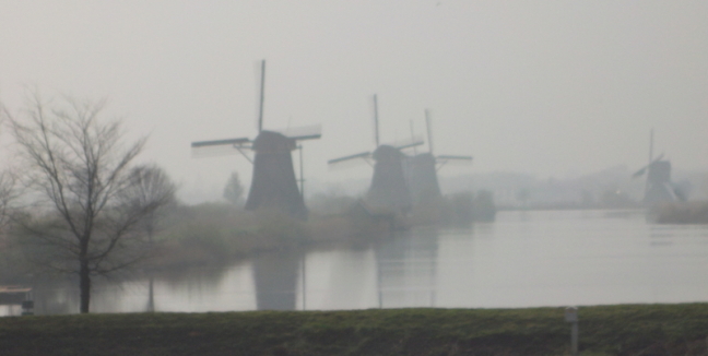 Some of the nineteen windmills in the mist at Kinderdijk, Netherlands