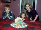  Wyatt, 'Bella, and Madi pose with their gingerbread house