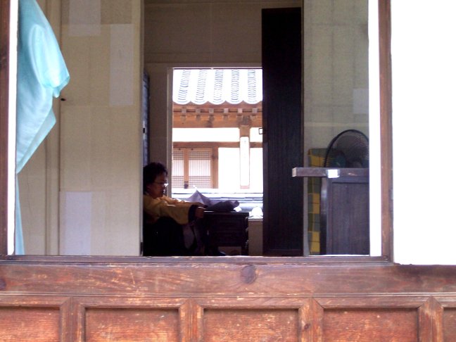 Reading a modern newspaper in an ancient house.